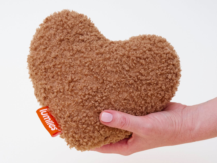 THE STUDIO HEART von lumiies, Kuschel- und Spielkissen für Hunde in Herzform aus hellbraunem Teddy-Sherpa, in der Hand gehalten